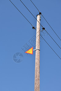 目的供应危险配有电线和蓝色天空警告标志的木柱图片