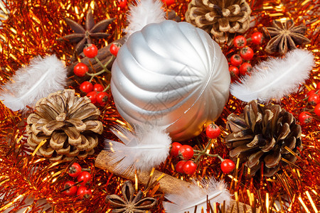 松果肉桂棒恒星羽毛和银色的黄瓜作为圣诞节的装饰品闪光亮的球图片