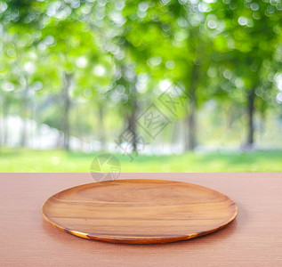 在模糊树背景上桌边的空圆木盘用于产品显示蒙戴为了服务空的图片