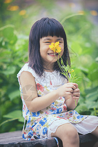 花园黄色的可爱女孩肖像与黄色宇宙花束在手牙般微笑的脸亚洲人图片