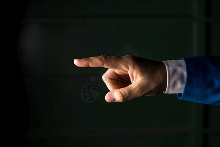 用手指向复制空间的孤立手用指向的商业概念用手指向复制空间的商业概念黑色背景之上的孤立手套装多于拇指图片
