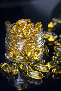 Omega鱼油软凝胶食品补充营养在健康生命和心脏概念栏中软胶囊人们罐图片