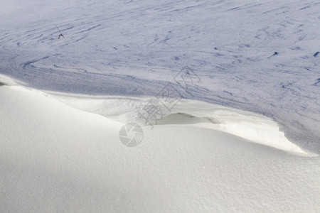 土地下雪的耀斑大漂向阳光关闭美丽的结构在冬天寒冷的雪中飘动体图片