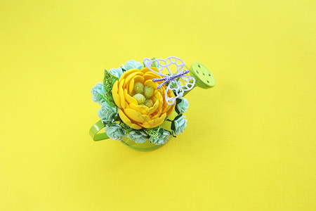 花的黄色手工造人花朵有闪光的叶子和许多绿色小水中的纸玫瑰在黄色背景和紫蝴蝶风下可使用小型绿水罐头植物群微型图片