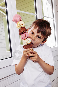 男小吃6岁时高冰淇淋甜筒的六勺巧克力香草和莓萨姆纳斯图片