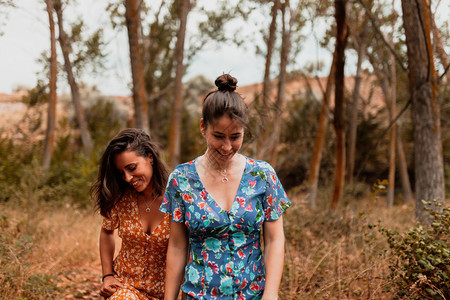 女孩两名身穿裙子的年轻妇女在森林中行走户外成人图片