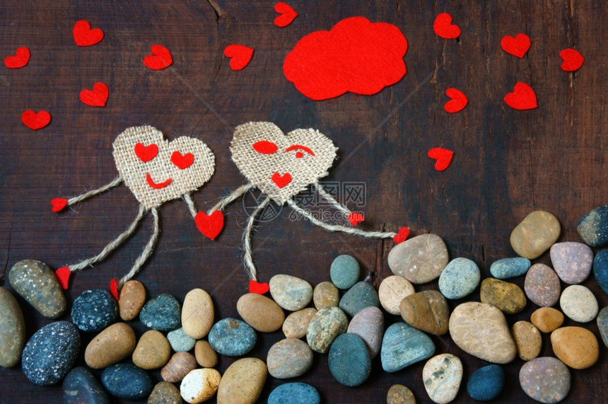 为了带着快乐情侣象征的有趣想法手牵走在石子上天空有红云心群情人节是爱的幸福抽象岩石图片