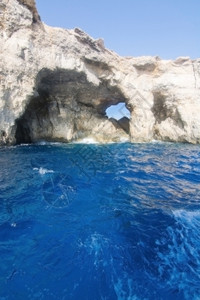在马耳他科米诺岛附近有山洞和蓝地中海洋水的利姆斯通岩石灰夏天蓝色的图片