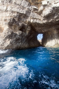 在马耳他科米诺岛附近有山洞和蓝地中海洋水的利姆斯通岩石靠近晴天气候图片