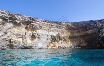 洞穴海上假期在马耳他科米诺岛附近有山洞和蓝地中海洋水的利姆斯通岩石图片