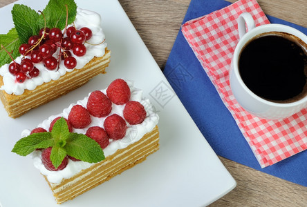 一块蜂蜜蛋糕加奶油和草莓鞭打桌子美味的图片