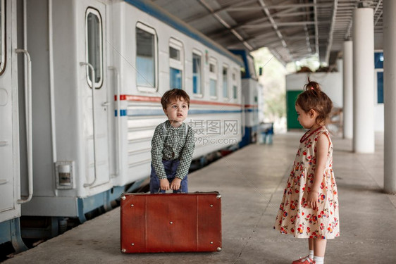 再见孩子在小火车站穿着旧衣服和式手提箱的男女小孩和少旅游图片