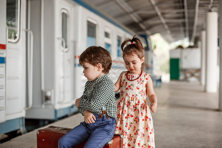 在小火车站穿着旧衣服和式手提箱的男女小孩和少子美丽图片