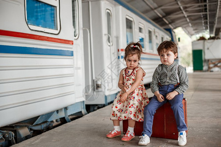 在小火车站穿着旧衣服和式手提箱的男女小孩和少爱情绪年轻的图片