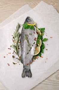 纸上加柠檬和香料的新鲜鳟鱼营养早餐平衡图片
