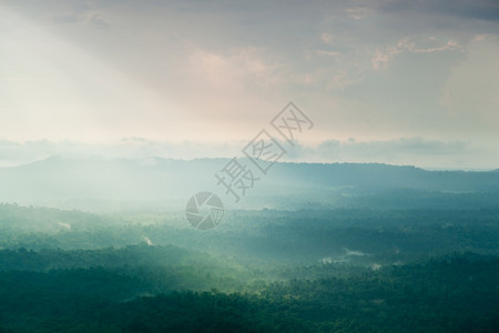 荒野日光照耀着云彩吹入山丘和森林雾笼罩的山岳和树木日落轮廓图片