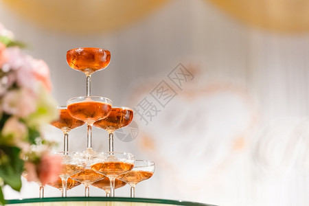 优雅的宴会婚礼时酒杯组将花束布在背景中迎合图片