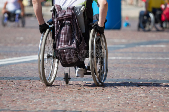 外部个人的残疾乘坐轮椅在路上行驶一种图片