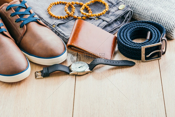 男漂亮的子时尚与SweaterJeansBeltSocks钱包手表和木本底棕色皮鞋旧光过滤器袜子商业图片