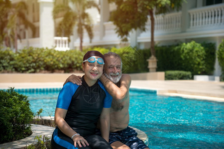 水池丈夫老年妇在游泳池共中放松户外图片