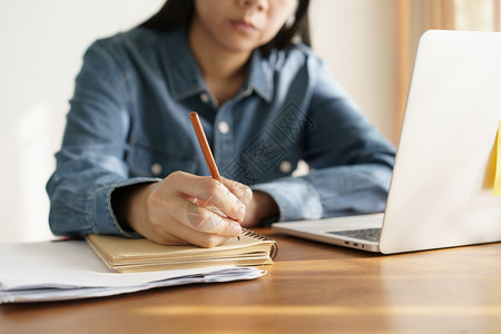 亚裔妇女在办公室用铅笔写记商业妇女工作教育随意的美丽图片