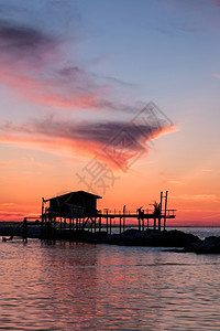 假期景观在海面的双影中一只美丽的红日落高楼房子在海面双影中垂直图片