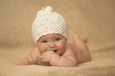 白色的可爱在床上戴白帽子的新生女婴白种人图片