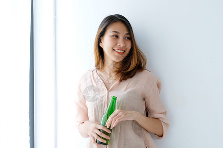 年青的亚洲妇女喝啤酒笑着快乐和生活方式的女社会图片
