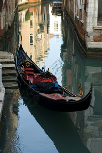 座位在意大利威尼斯运河的一套楼梯旁停靠着一只金币正面水图片