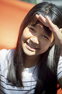 亚洲人美丽的吸引使用手保护青少年在脸皮上晒太阳图片