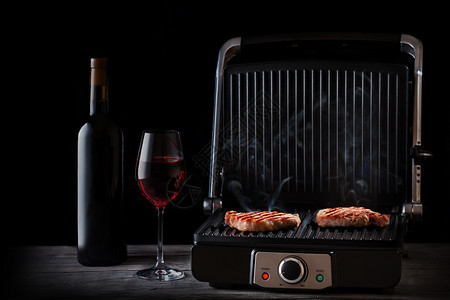鸡肉和红酒放在木桌上黑本底的奢华风格烤肉和红酒放在木桌上一种葡萄酒牛扒图片