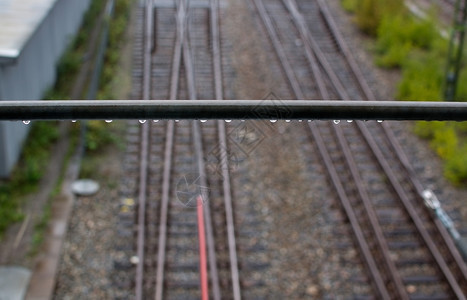 铁路轨道上扶的雨滴在斯德哥尔摩郊区附近变化在一个雨季铁路轨道上扶的雨滴户外车站导轨图片