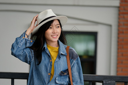 漂亮的年轻在城市户外背景中微笑的年轻亚洲女临时生活者旅行博客兼游肖像图片