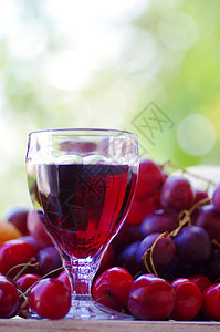 一杯红酒和木桌上的水果浆长相思束图片