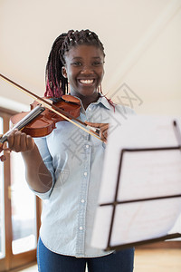 学习乐器音高中女学生在玩violin游戏的肖像图片