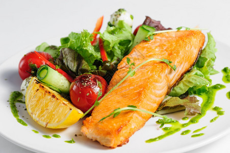 健康盘子上的灰鲑鱼和新鲜蔬菜沙拉面粉中的灰浆鲑鱼和蔬菜白色的餐厅图片