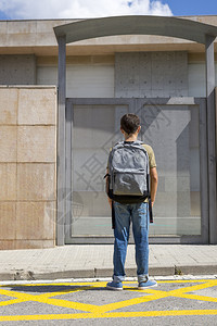 学生男带着他的背包好孩子站在学校门口着夏天图片