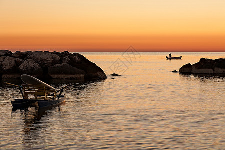 平静的早晨渔民在清的黎明等待着回到船上在黎明的清晨等待着回到其网络的渔民反射背景图片