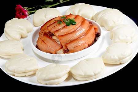 吃蔬菜食品蒸面包黑背景的猪肉蒸熟图片