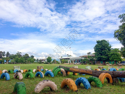 蓝色的农村学校角由多彩轮子组成的操场美丽绿草春天图片