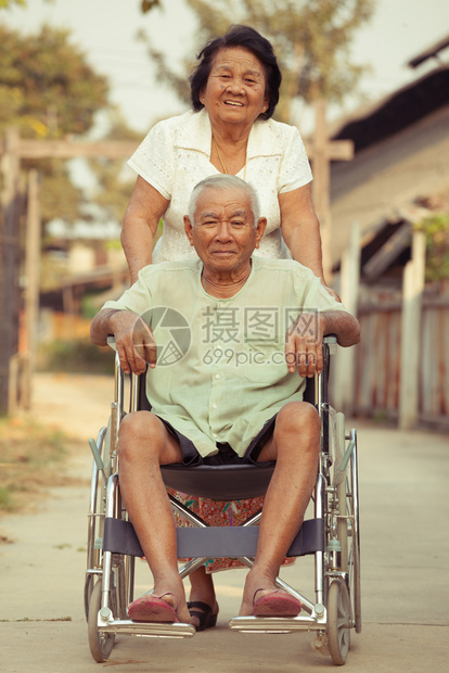 老年女性推着轮椅陪丈夫散步图片