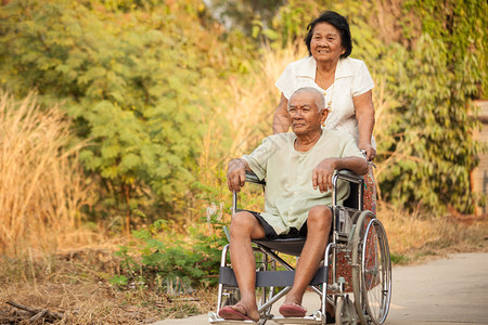 公园里推着轮椅散步的老年夫妻图片