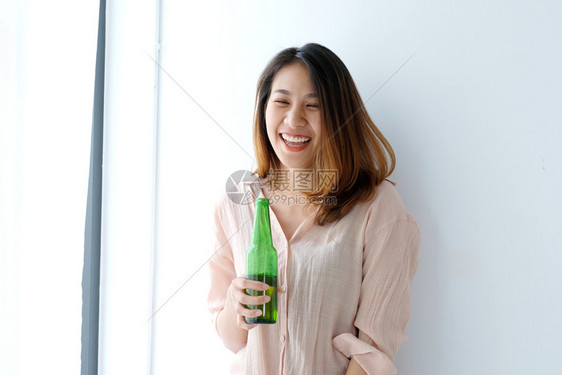 寒意随的出去亚裔妇女在聚会庆祝活动生方式上喝啤酒图片