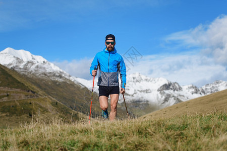 徒步旅行者北欧人走在山上一个年轻人营跑步图片