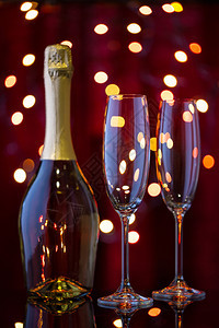 酒精一瓶香槟和两个空杯子在新年散景中庆祝和圣诞节的概念在新年散景中一瓶香槟和两个空杯子金的庆典图片