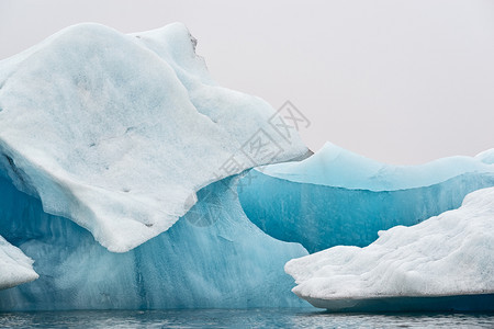 漂浮的冰岛瓦特纳川附近的Jokulsarlonrsquos湖中的冰山岛湖中的山蓝色莫比代利图片