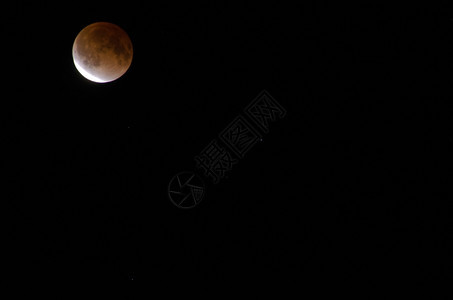 行星磁盘系统月食期间的亮食期间的红亮在黑色天空图片