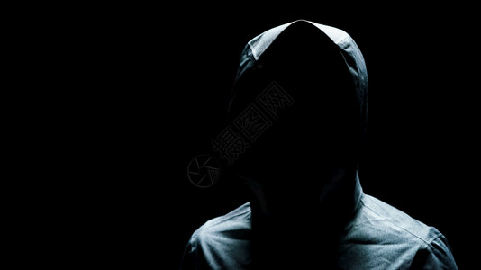 男人运动衫缠扰者黑背景蒙面的隐形人身戴黑底头罩的肖像图片