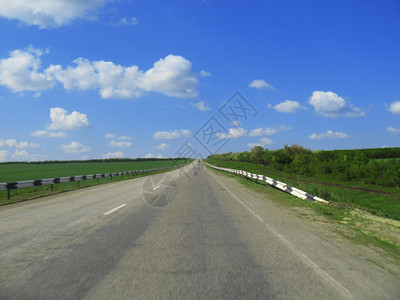 横宽的高速公路和草地云穿越蓝天空迅速的全景度图片