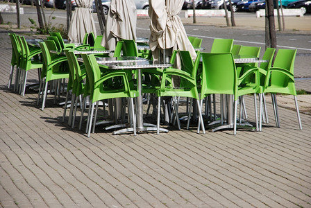 酒吧市中心咖啡配有绿色塑料椅金属桌和雨伞的户外自助餐厅图片